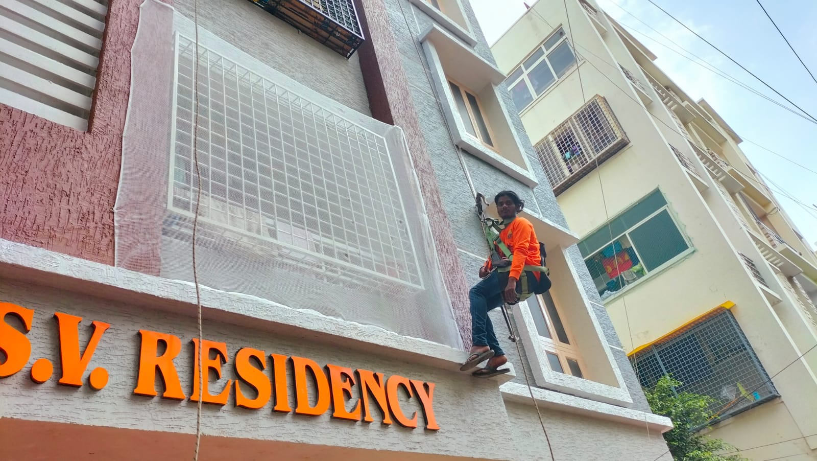 a skillful technician installing a safety net for a building in Madurai